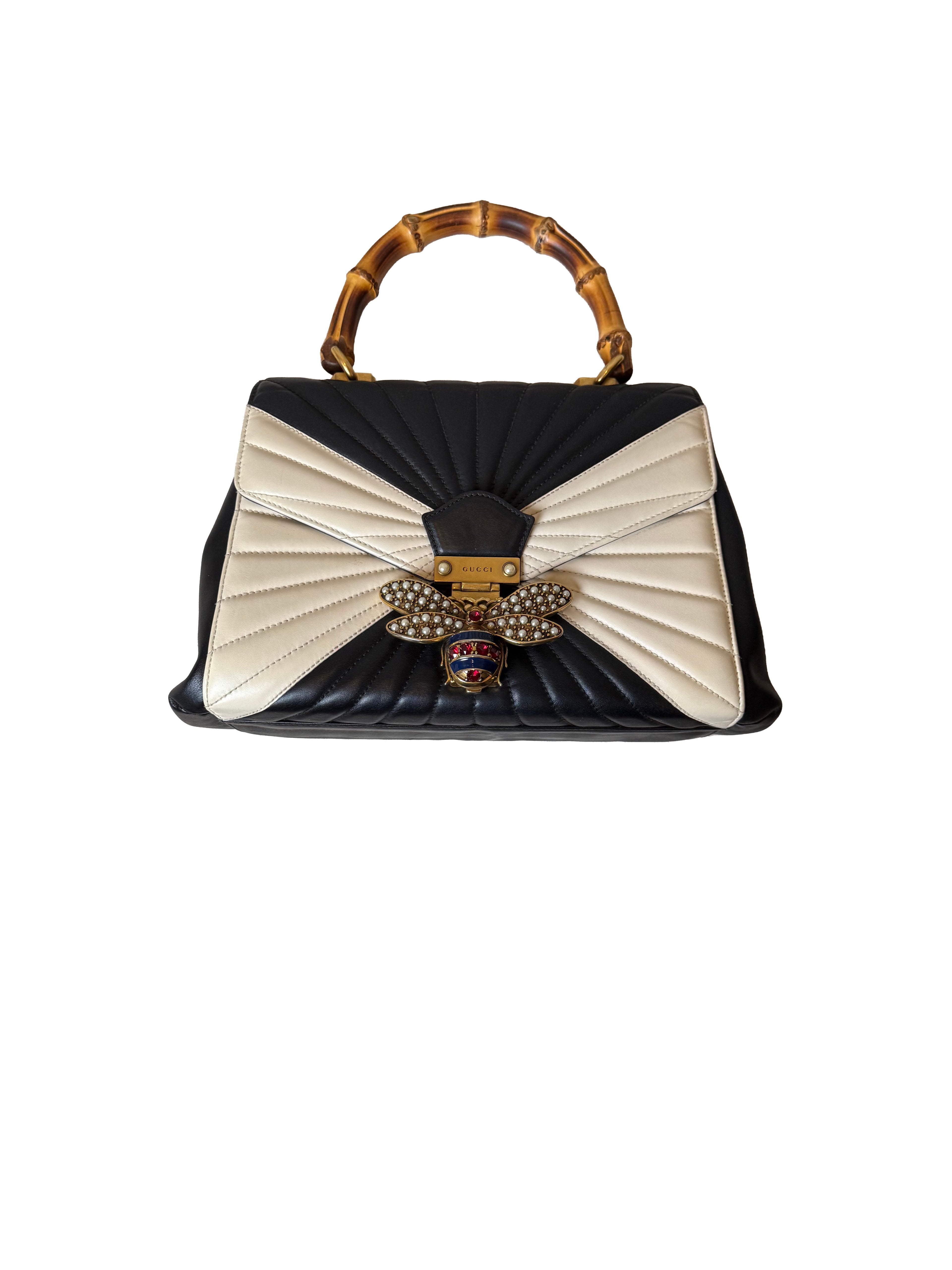 Black and white handbag with decorative handle on a white background