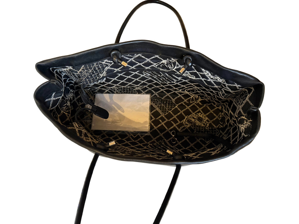 Black handbag with decorative mesh interior on a white background