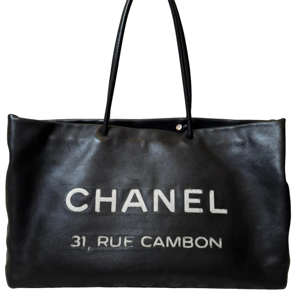 Black Chanel handbag with '31 Rue Cambon' text on a white background