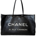 Black Chanel handbag with '31 Rue Cambon' text on a white background